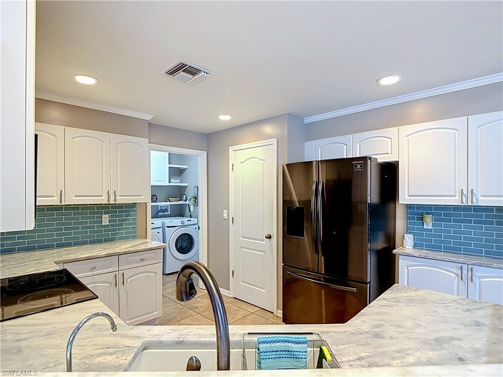 Kitchen featuring white cabinetry, light countertops, and a blue subway tile backsplash