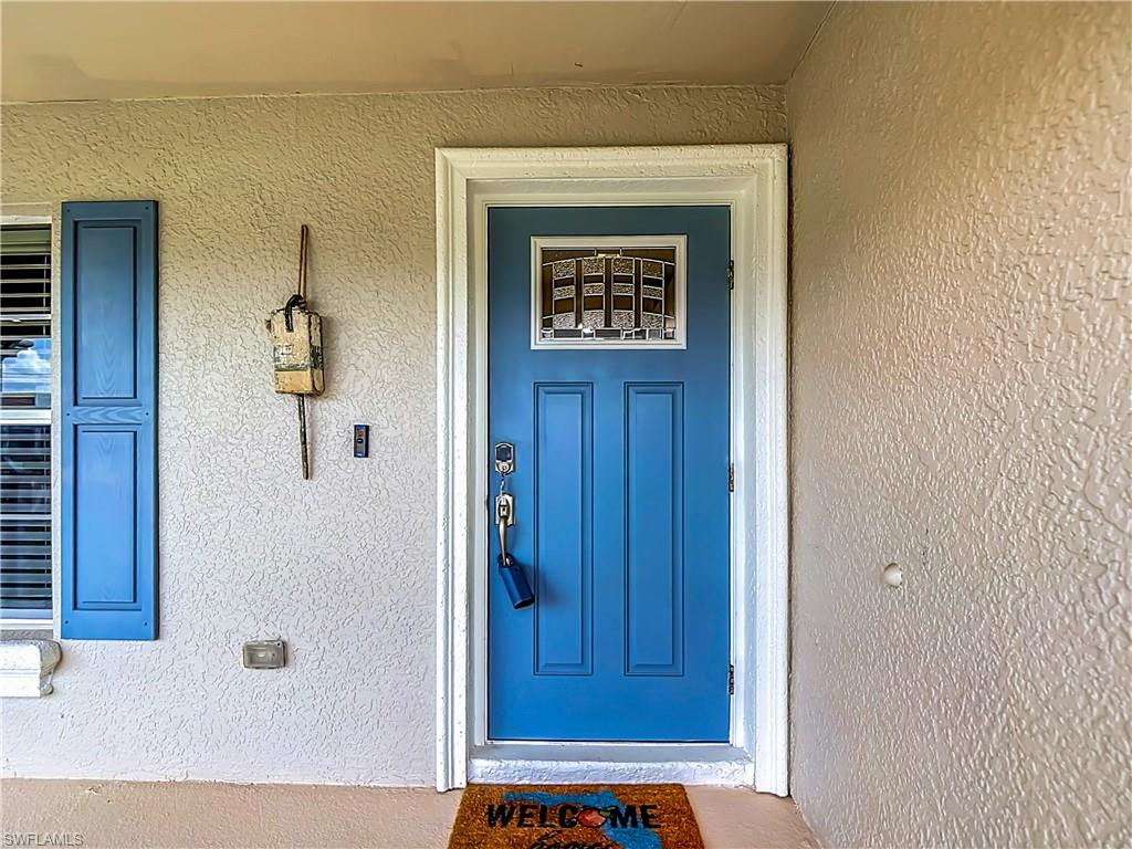 Blue paneled front door with decorative glass insert