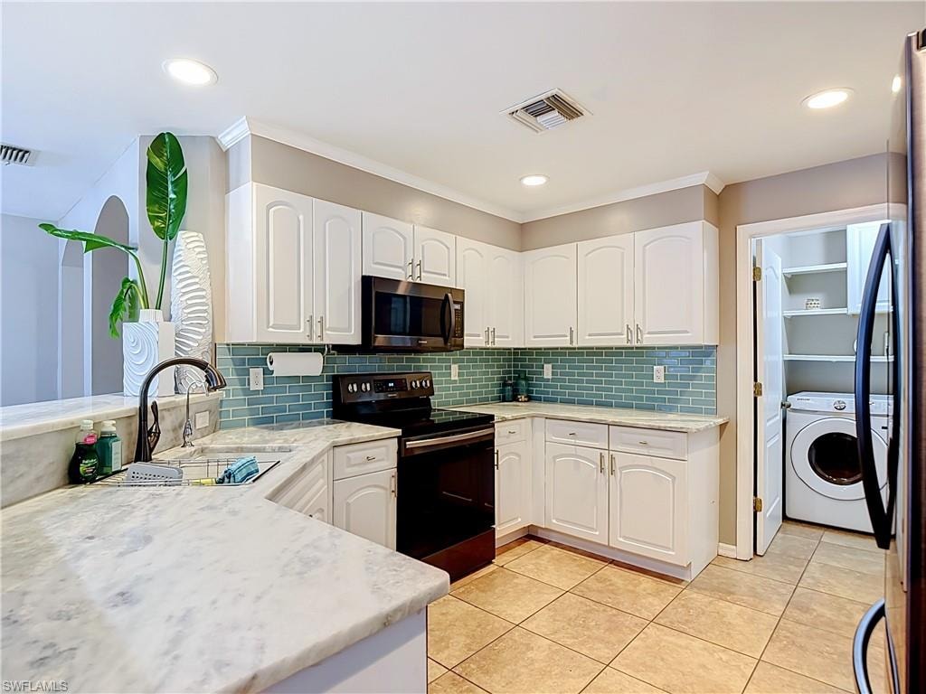 Kitchen featuring white cabinetry, light-toned countertops, a blue subway tile backsplash, and recessed lighting