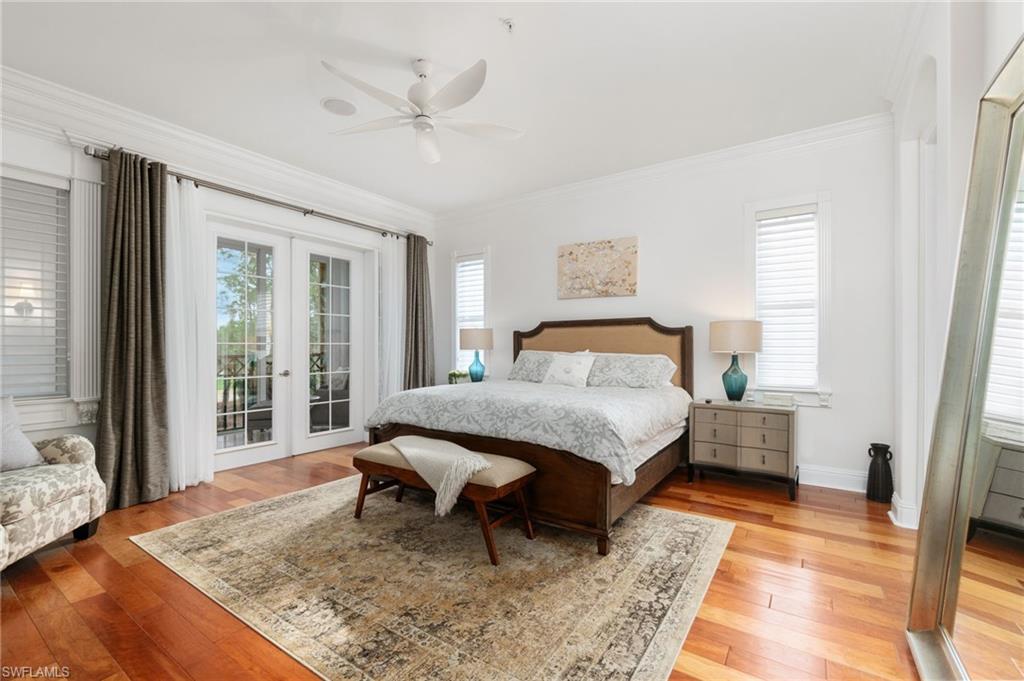 Master bedroom with beautiful wood flooring has sliders out to the glassed in lanai.
