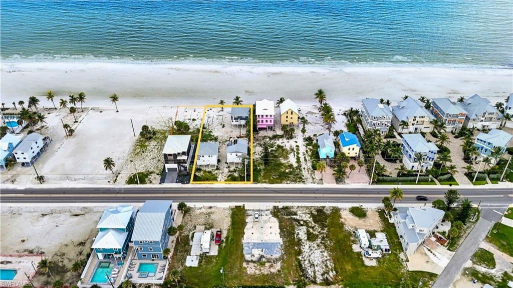 Beachfront property featuring direct access to the sand, established palm trees, and an open lot layout