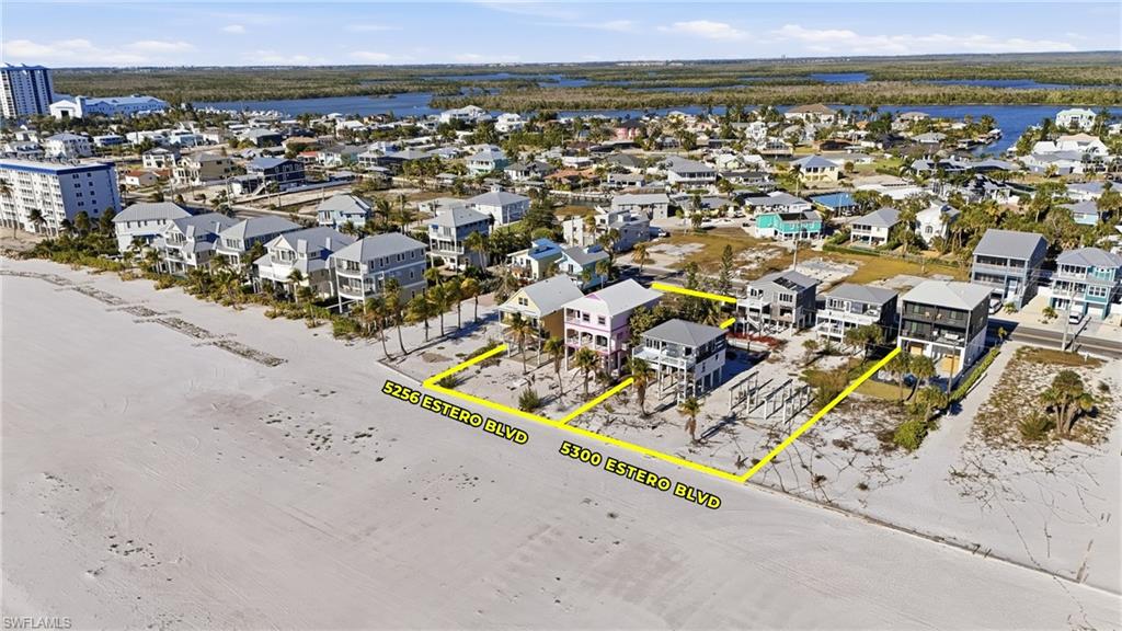 Aerial view showcasing two distinct properties with direct sand access
