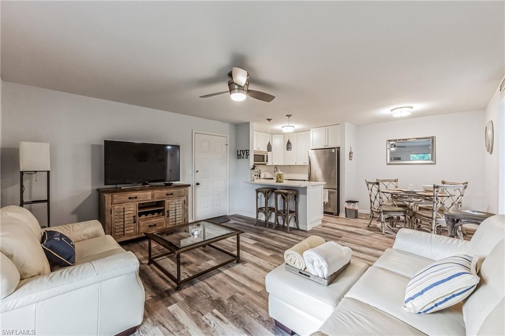 Open-concept living space featuring wood-finish flooring, a ceiling fan, and recessed lighting