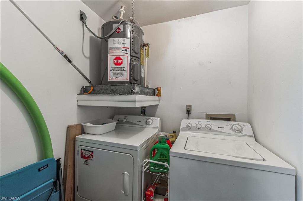 Dedicated utility area featuring a water heater, a washer, and a dryer