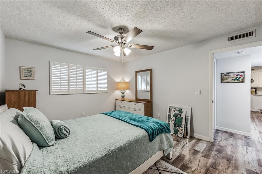 Bedroom featuring wood-finish flooring and a ceiling fan with light fixture