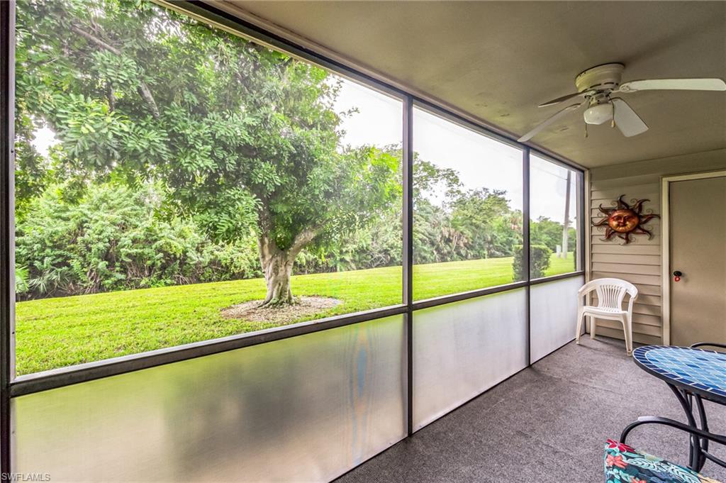Screened lanai featuring a ceiling fan, textured flooring, and a solid exterior door