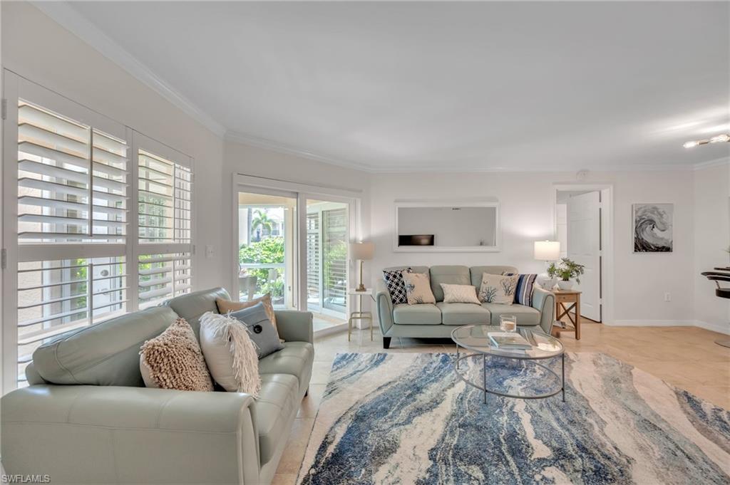 Living area featuring neutral wall tones, crown molding, tile flooring, and white plantation shutters