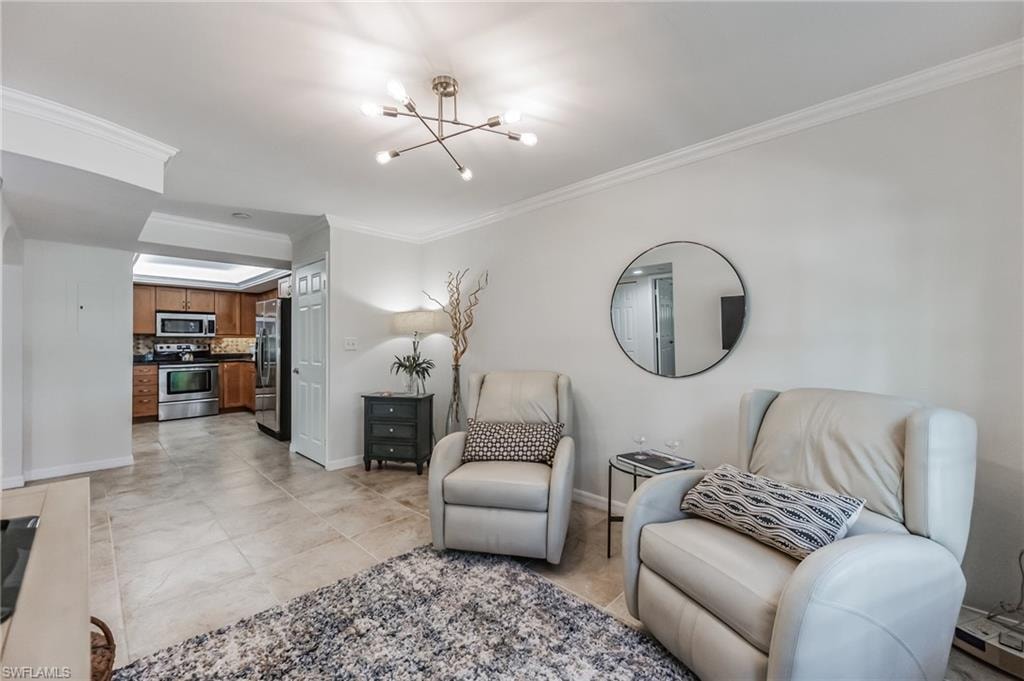 Bright living area featuring a modern light fixture and crown molding