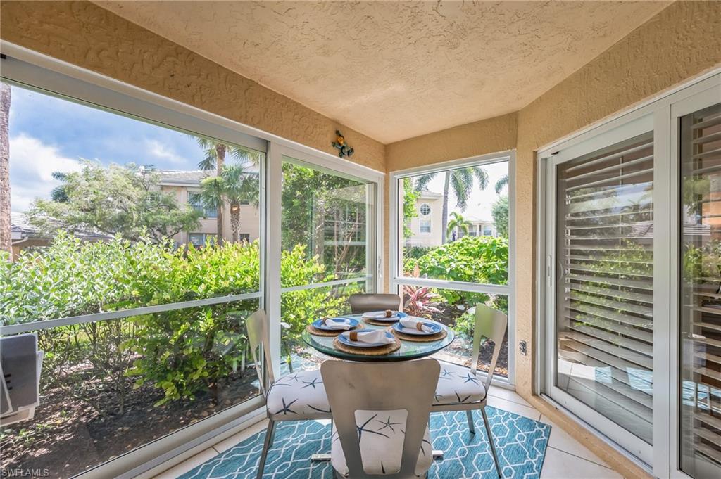 Enclosed patio featuring floor-to-ceiling windows, textured stucco walls, and tile flooring