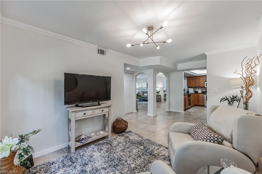Living area featuring a contemporary ceiling fixture, crown molding, and tiled flooring
