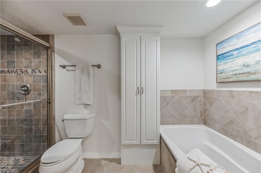 Well-appointed bathroom featuring a glass-enclosed shower with tiled surround, separate soaking tub with tiled wainscoting, and built-in white cabinetry