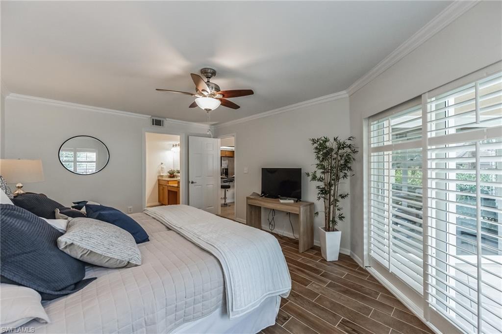 Spacious bedroom featuring wood-finish tile flooring, a ceiling fan, and crown molding