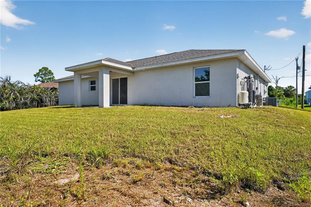 Rear exterior featuring a covered patio, sliding glass door entry, and multiple windows