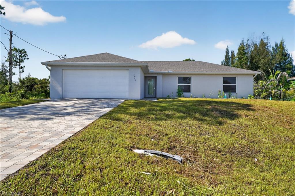 Single-story residence featuring a gray exterior, a two-car garage, and a paver driveway
