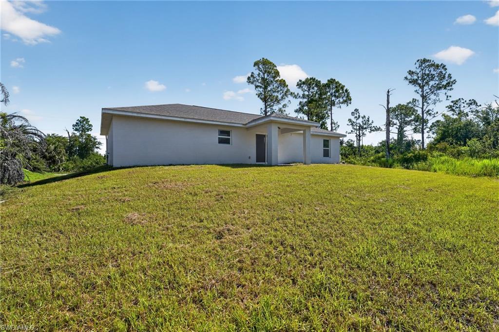 Contemporary single-story exterior featuring a covered entry, neutral stucco finish, and a dark shingle roof