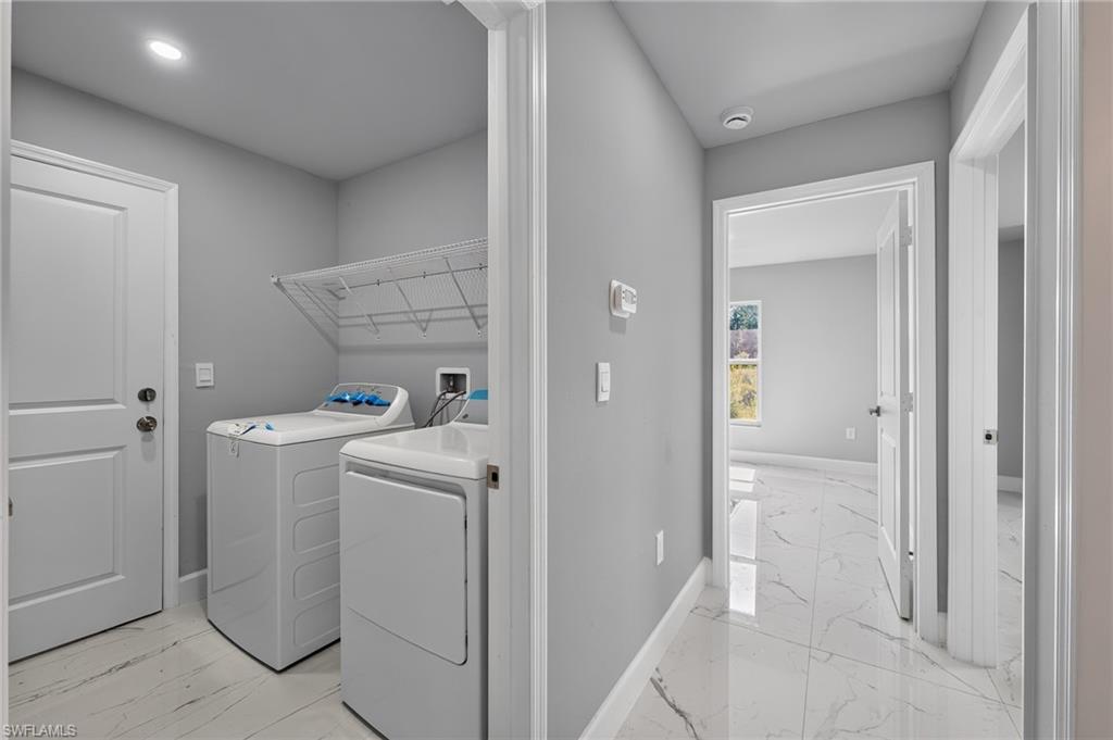 Dedicated laundry area featuring a white wire shelving unit, overhead recessed lighting, and a neutral wall color