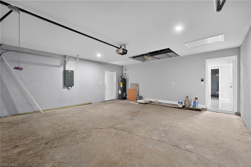 Spacious garage featuring a concrete floor, recessed lighting, white walls, and an overhead garage door mechanism
