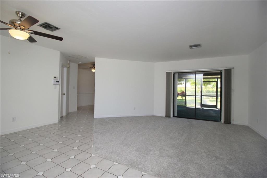 Carpeted spare room featuring ceiling fan