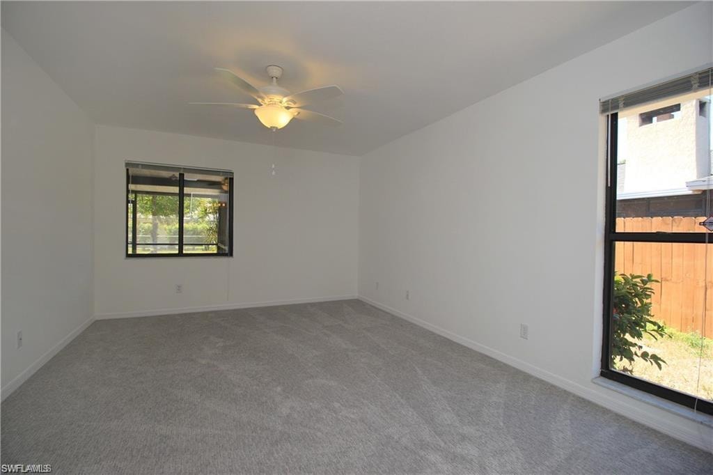 Carpeted spare room with ceiling fan