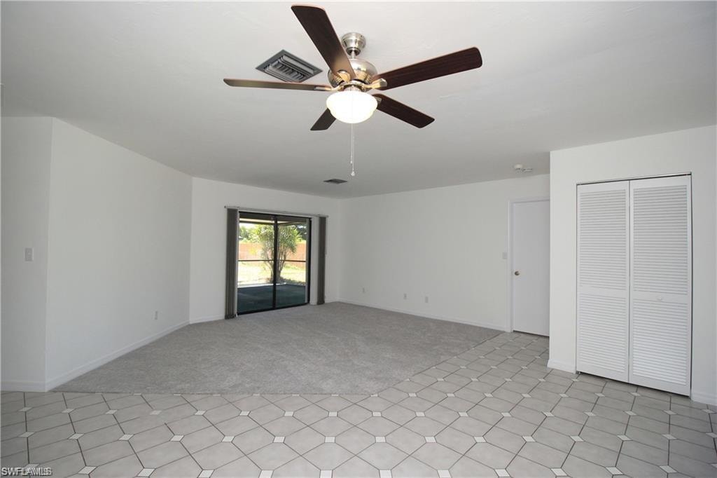 Carpeted empty room featuring ceiling fan