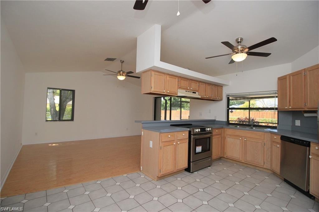Kitchen with ceiling fan, stainless steel appliances, and light tile flooring