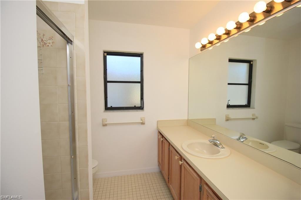 Bathroom featuring tile flooring, oversized vanity, and toilet