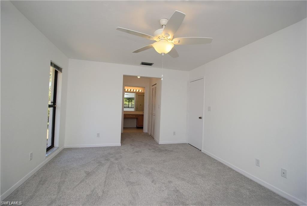 Carpeted empty room with ceiling fan