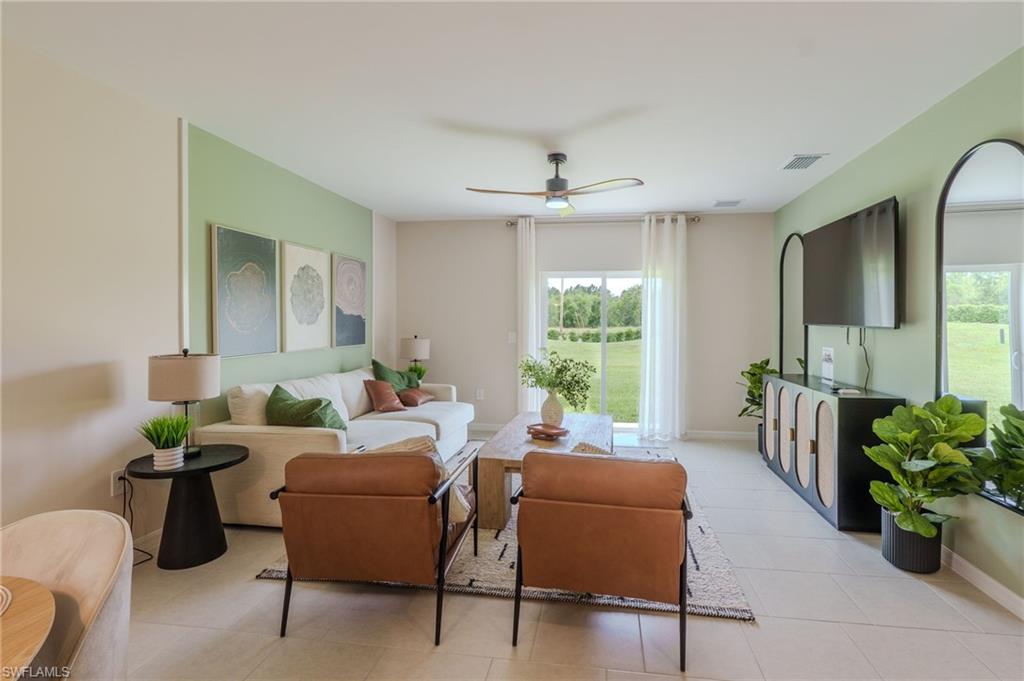 Bright living area with light tile flooring and a ceiling fan