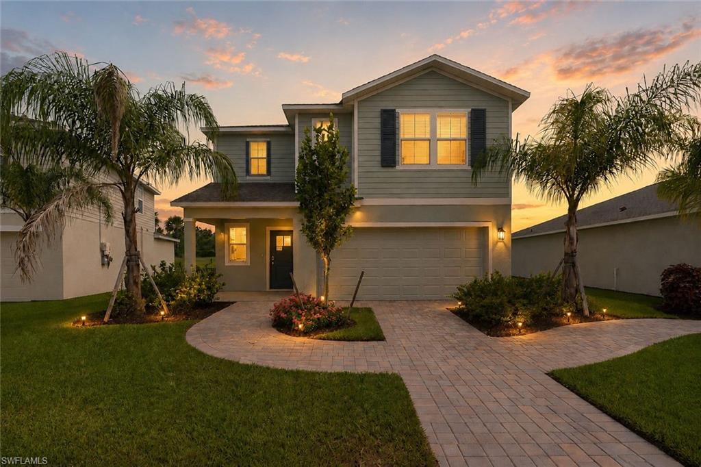 Two-story residence featuring light green siding and dark shutters