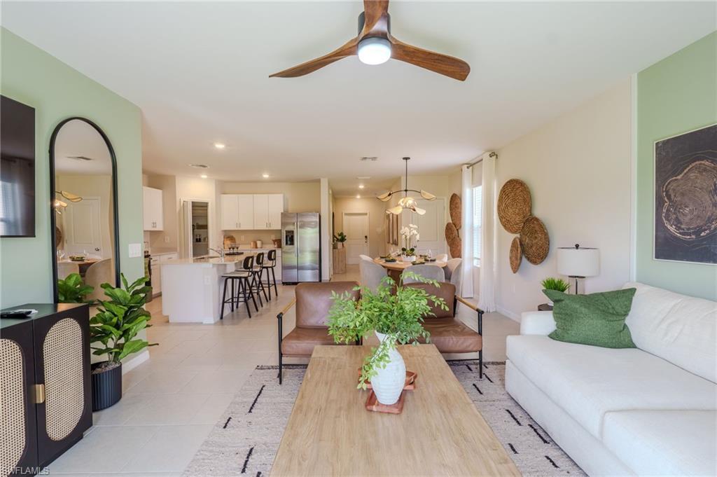 Open-concept living area featuring a wood-finish ceiling fan, recessed lighting, tile flooring, and light-toned wall paint