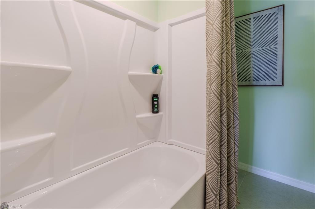 White integrated tub and shower unit featuring built-in shelving