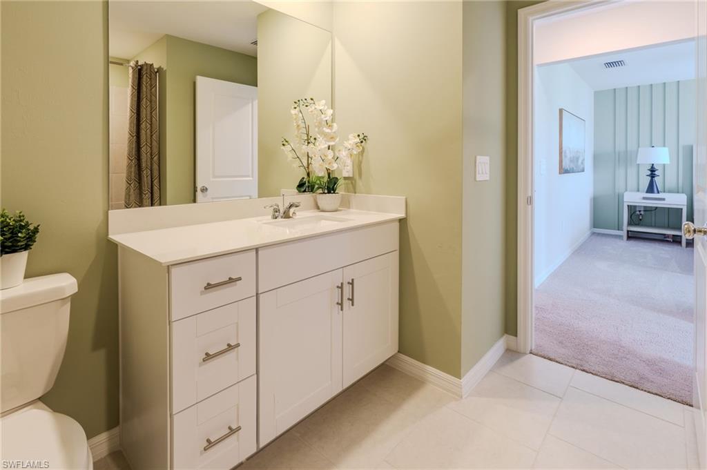 Bathroom vanity featuring a white countertop, undermount sink, and chrome faucet