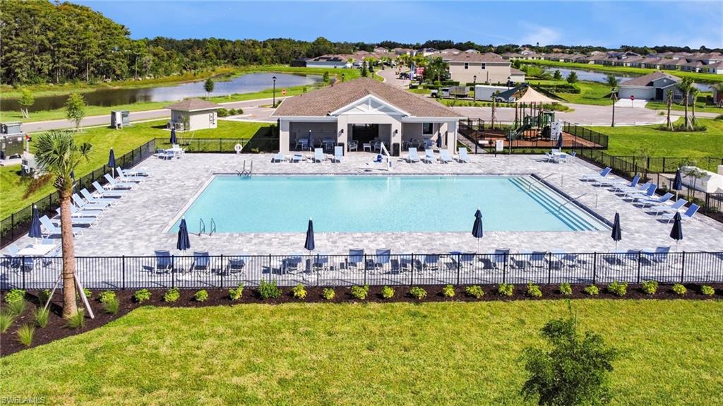 Expansive community pool with a surrounding paver patio and ample lounge seating