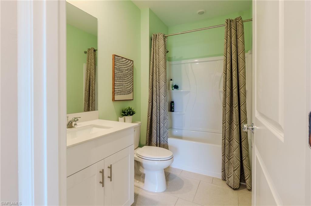 Bathroom featuring a white vanity with an integrated sink, polished chrome faucet, and a large wall-mounted mirror