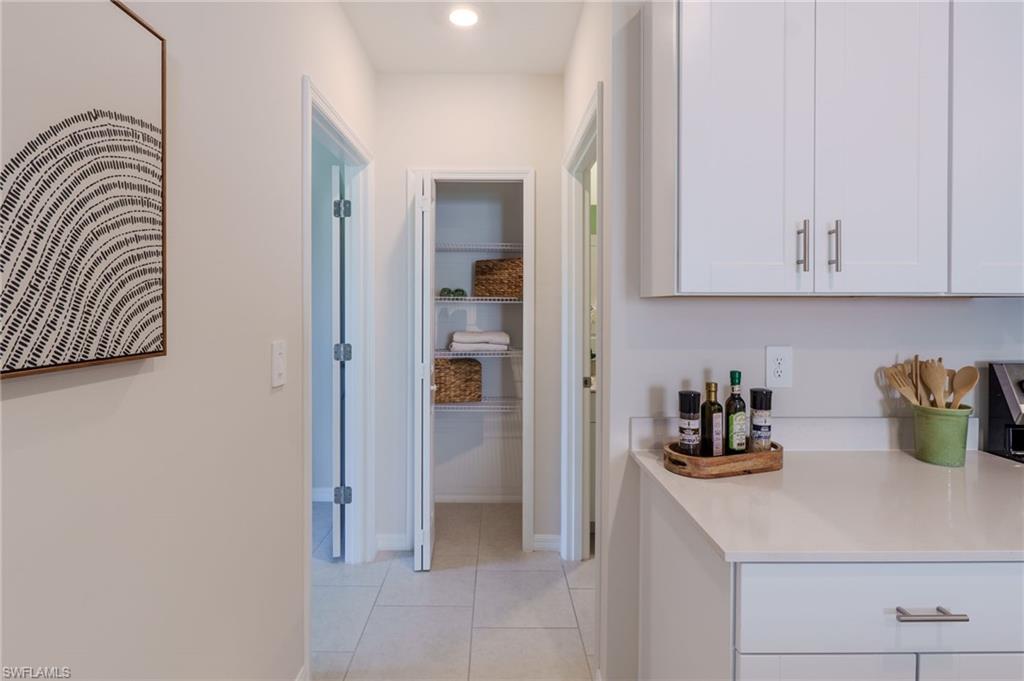 Kitchen featuring white cabinetry with brushed nickel hardware, light-toned countertops, and recessed lighting