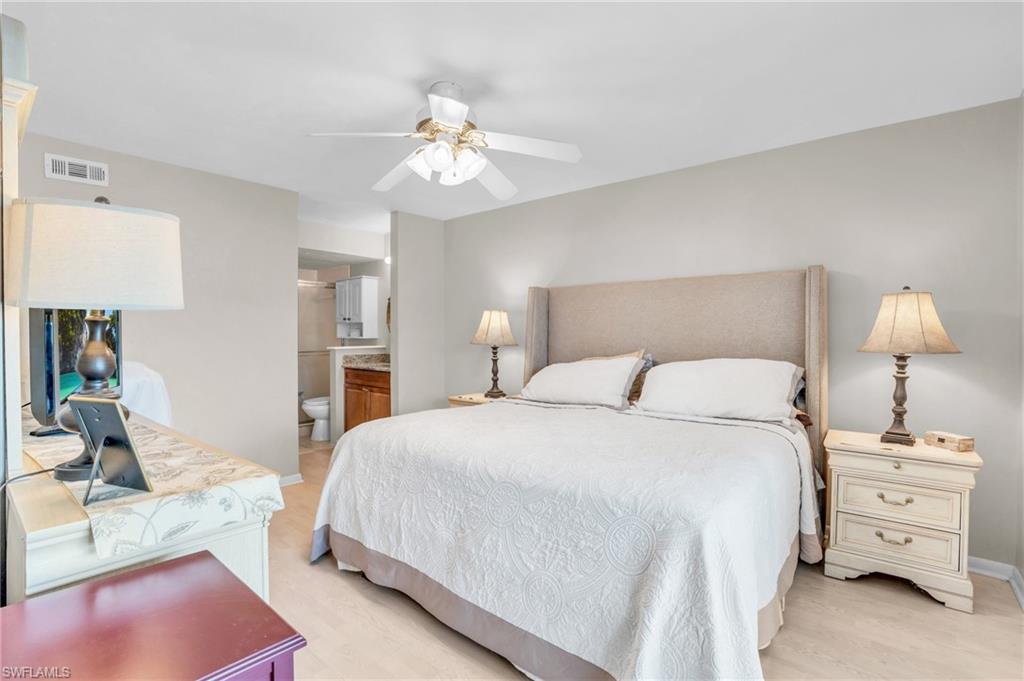 Bedroom with ceiling fan, connected bathroom, and light hardwood / wood-style floors