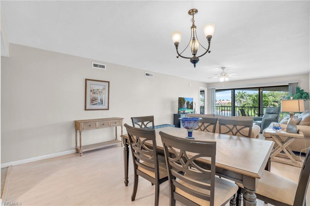 Dining space featuring light hardwood / wood-style floors and ceiling fan with notable chandelier