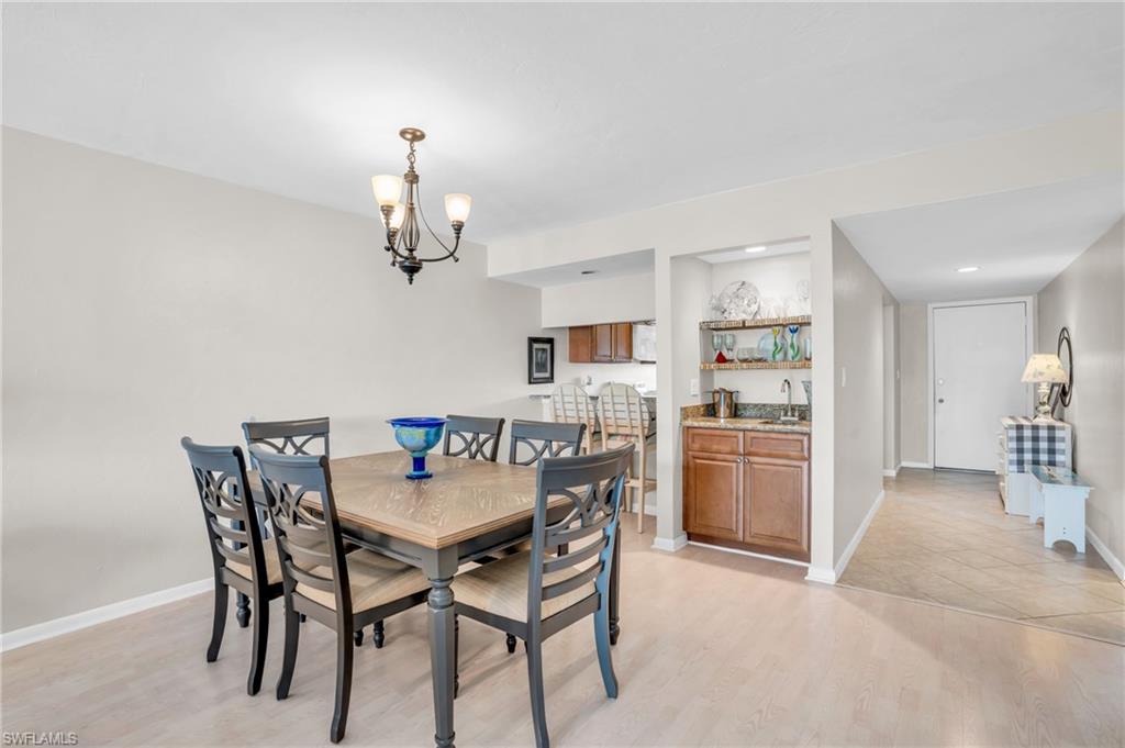 Dining room with sink, a notable chandelier, and light hardwood / wood-style floors