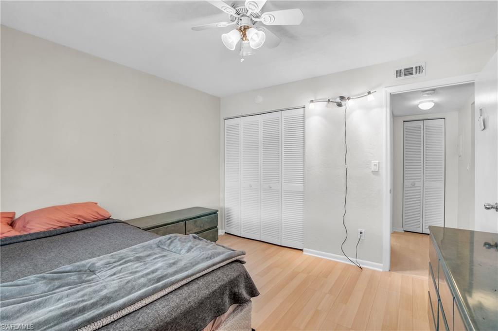 Bedroom with ceiling fan, light hardwood / wood-style flooring, and a closet