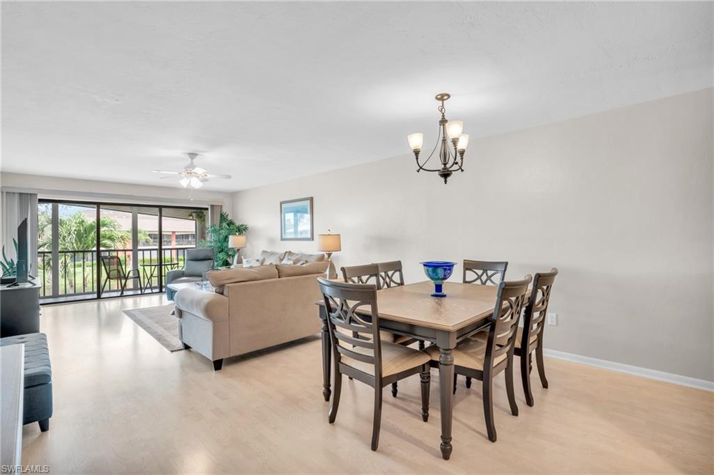 Dining area with ceiling fan with notable chandelier and light wood-type flooring