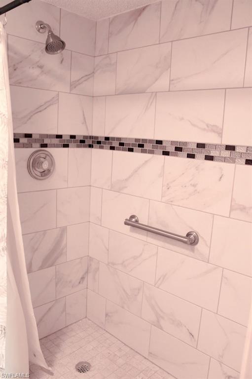 Full bath featuring a tile shower and a textured ceiling