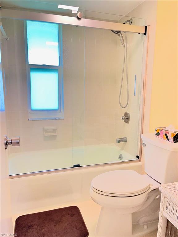 Tub and shower combination with sliding glass doors.