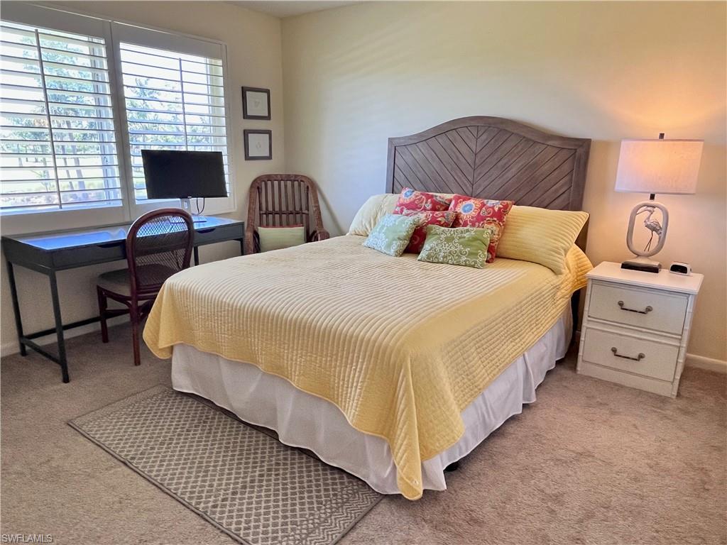 Queen size bed with golf course views with a desk and recliner and dresser,