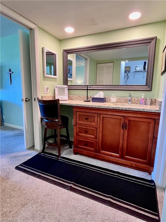 Single vanity with a large counter and chair for makeup.