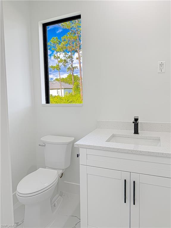 Modern bathroom featuring a white vanity with shaker-style cabinetry, a light speckled countertop, and a rectangular undermount sink with a matte black faucet