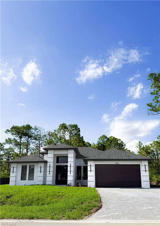 Contemporary single-story residence featuring a dark asphalt shingle roof, white stucco exterior, and black garage door