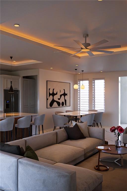 Open-concept living space with recessed lighting and tray ceilings