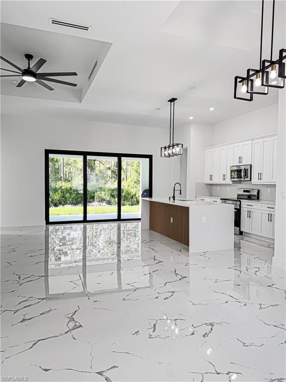Open concept living space featuring large format marble-look tile flooring
