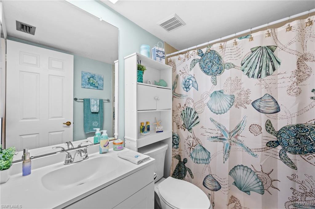 Bathroom featuring a white vanity with an integrated sink, polished chrome faucet, and a large wall-mounted mirror