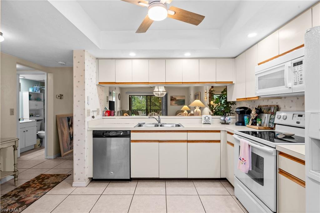Kitchen featuring white cabinetry with wood-tone accents, recessed lighting, and a ceiling fan